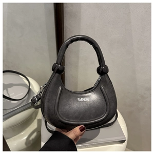 Dettaglio borsa a mezzaluna grigia vintage con trama in pelle e nodi a sfera neri