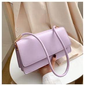 Close-up of lavender purple shoulder bag with gold cylindrical hardware details