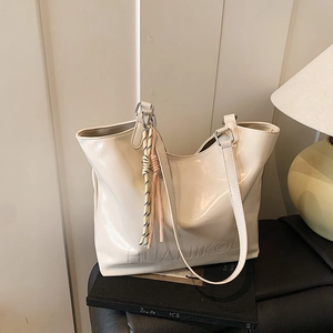 Glossy white large tote bag with braided rope charm and embossed detail for women