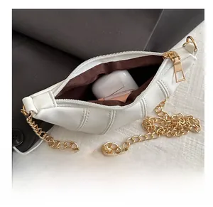 Internal view of white pleated crescent bag showing storage for cosmetics and earphones