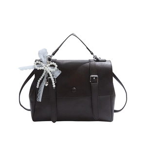 Vintage dark brown satchel handbag with elegant pearl lace bow charm and top handle.