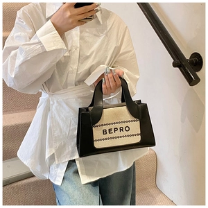 Detail of fashion square handbag with BEPRO lettering and leather trim on canvas