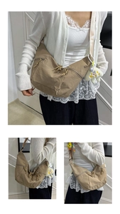 Detail of khaki nylon crescent bag with plush doll charm and functional side pockets