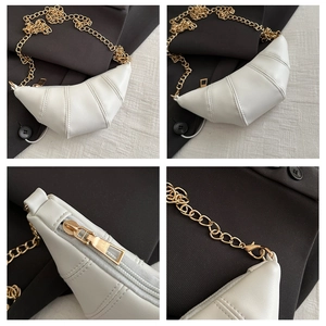 Detail of white crescent bag with premium gold chain and precise stitching texture