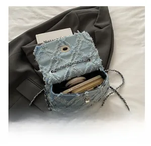 Vue intérieure montrant la capacité de rangement du sac à bandoulière en denim bleu