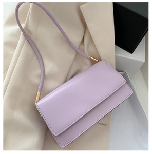 Detail view of a lavender rectangle flap shoulder bag with smooth leather and gold hardware