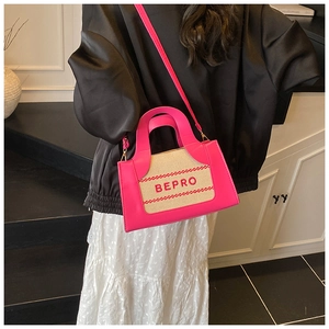 Detail of pink and beige canvas crossbody bag with BEPRO embroidery on a female model