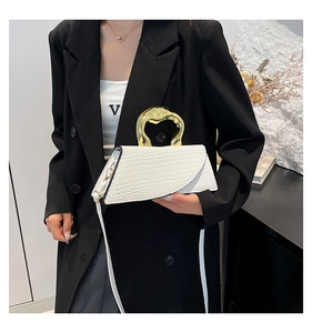 Dettaglio borsa bianca effetto coccodrillo con elegante manico in metallo dorato