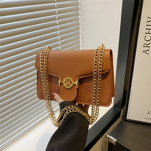 Chic caramel brown baguette bag with embossed flower pattern and gold chain strap
