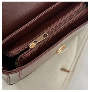 Detailed close-up of dark brown leather bag interior with smooth gold metal zipper