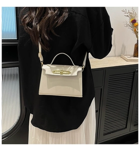 Dettaglio posteriore della borsa beige a tracolla con chiusura dorata e cinturino