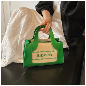 Detail of green and beige canvas patchwork handbag with BEPRO embroidery and wavy trim