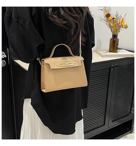 Detail view of khaki structured crossbody bag with gold metal buckle and top handle