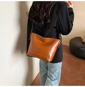 Detailed view of caramel brown oil wax leather texture on a minimalist tote bag strap