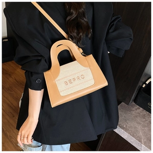 Detail of a chic camel leather crossbody bag with BEPRO lettering and beige fabric panel