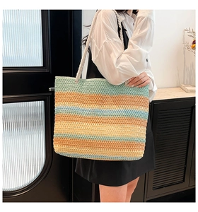 Détail du sac cabas en paille à rayures arc-en-ciel avec des anses en corde pour la plage