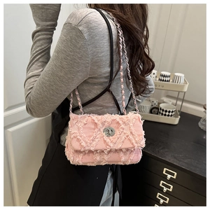 Gros plan détaillé du sac matelassé rose avec bords effilochés et fermoir rotatif argent