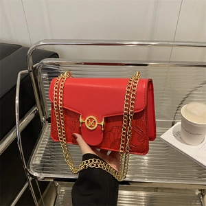 Red leather baguette shoulder bag with leaf embossing and gold M buckle and chain straps