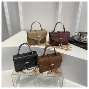 Detail view of four vintage matte leather crossbody bags in khaki, red, black, and brown colors