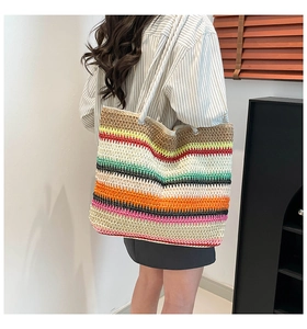 Gros plan sur la texture rayée colorée et les anses en corde du sac de plage tissé
