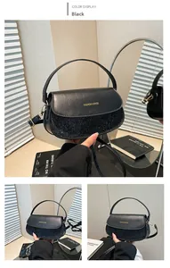 Detail der schwarzen Pailletten-Satteltasche mit Goldlogo und verstellbarem Gurt