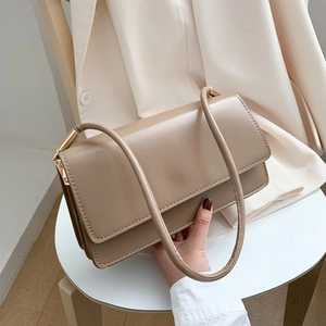 Minimalist beige leather underarm bag with accordion gussets and gold hardware details