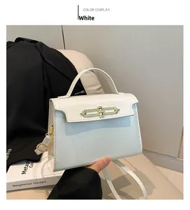 Close-up of white leather handbag with golden lock clasp on minimalist background
