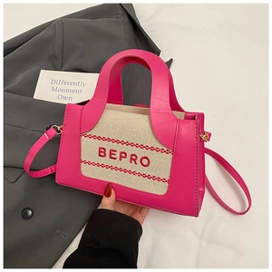 Detailed shot of pink and beige patchwork bag with red BEPRO embroidery and gold hardware