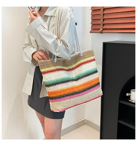 Détail d'un grand sac cabas tissé arc-en-ciel avec des anses en corde sur un mannequin