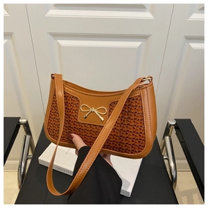 Détail du sac en cuir marron avec texture tressée et nœud métallique doré chic