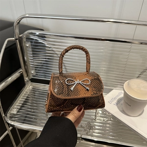 Brown snakeskin mini handbag with silver bow detail and chain strap for women