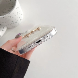 Close-up of clear phone case with golden metal kickstand and pearl texture