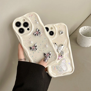 Cream iPhone case with 3D glitter bows, butterfly crystals, and pearl accents