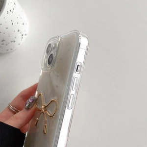 Detailed side view of iPhone case featuring a 3D gold metal bow and precise cutouts