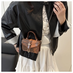 Detail of brown snake skin mini crossbody bag with metal chain strap and top handle