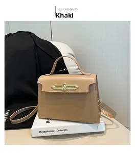 Detail of khaki faux leather shoulder bag with elegant golden twist lock and top handle