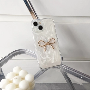 Detail of pearlescent texture and gold metal bow decoration on protective iPhone case