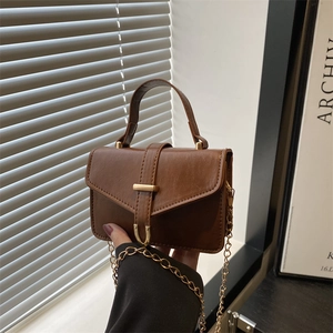 Brown faux leather handbag with belt buckle detail and gold chain shoulder strap