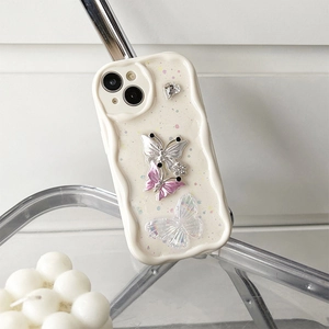 Detail of cream wavy phone case with 3D metal butterfly, rhinestones and pearls