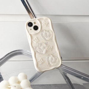 Detail of cream wavy iPhone case with 3D resin hearts, pearl bows and glitter finish
