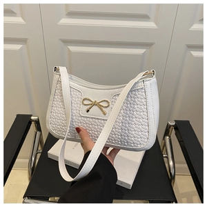 Détail du sac sous le bras tissé blanc avec boucle nœud doré et bandoulière