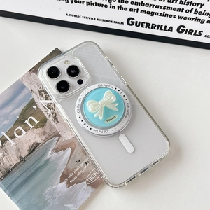 Close-up of a blue phone grip with a white 3D bow on a transparent iPhone case