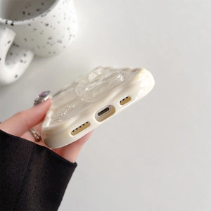 Close-up of cream wavy edge iPhone 16 Pro Max case with 3D embossed heart decoration