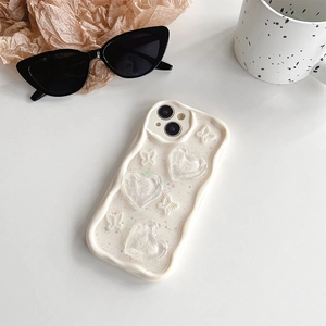 Close-up of wavy cream phone case with 3D resin hearts, bows, and glitter accents