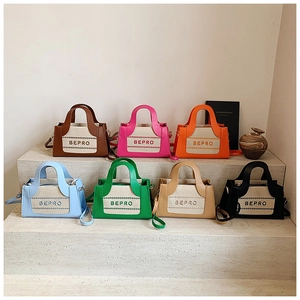 Collection of seven colorful canvas contrast handbags displayed on stone steps