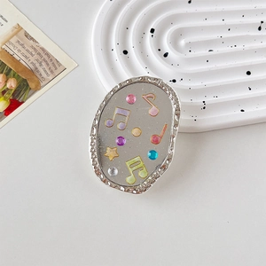 Détail du support téléphone notes de musique pailletées avec étoiles et strass multicolores