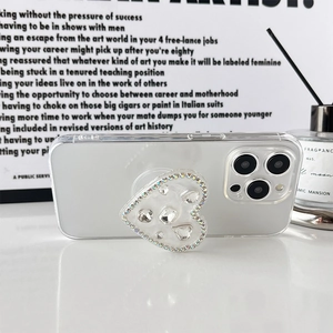 Detail of a sparkling heart phone grip with rhinestones on a clear case in a lifestyle set