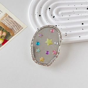 Détail d'un support de téléphone ovale avec paillettes d'étoiles et bordure argentée