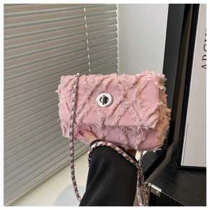 Vue détaillée du sac en jean rose matelassé avec bords effilochés et bandoulière en chaîne