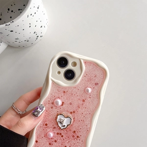 Dettaglio custodia iPhone rosa glitterata con perle e emblema di rosa in rilievo